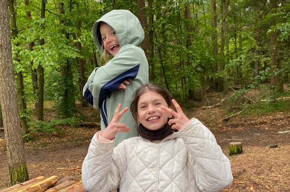 Zwei_Schuelerinnen_stehen_im_Wald_und_haben_Spass