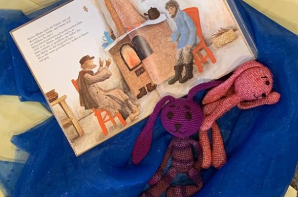 offenes Buch mit Schulmaskottchen in Form von gehäkelten Hasen