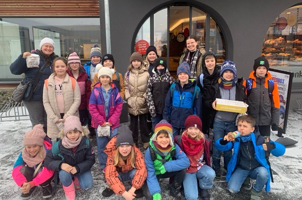 Gruppenbild vor der Bäckerei mit allen Schulkindern und Betreuerinnen