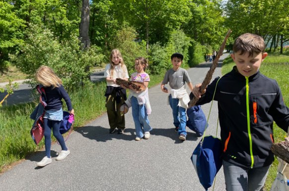 Schulergruppe_beim_Waldspaziergang_tragen_Baumrinde_die_sie_gesammelt_haben