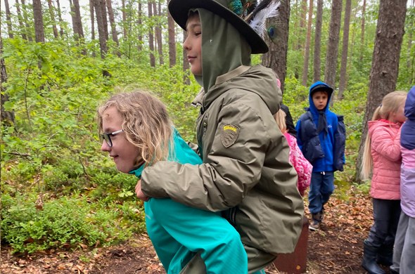 Zwei_Schueler_spielen_im_Wald_einer_traegt_den_anderen_Huckepack