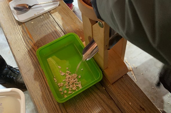 Ein Schüler testet die Funktion einer Getreidequetsche und produziert Haferflocken